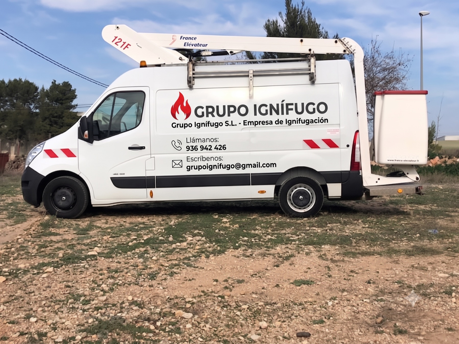 Furgoneta rotulada de Grupo Ignífugo, empresa de ignifugación en Barcelona, con plataforma elevadora